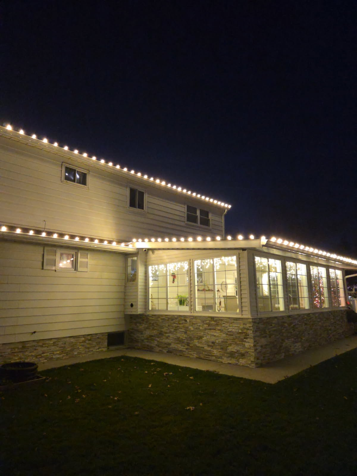Warm white Christmas lights installed along a home roofline